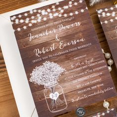 wedding stationery with mason jar and string lights on wooden boards, including the bride and groom's initials