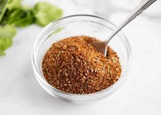 a glass bowl filled with spices next to lettuce