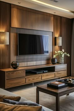 a living room with a large television on top of a wooden entertainment center next to a window