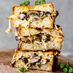 three slices of bread stacked on top of each other with mushrooms and cheese in them