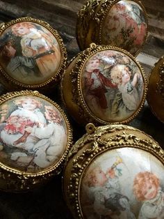 six small round paintings are on display in ornate gold frames, all painted with different colors and sizes