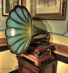 an old phonograph sitting on top of a wooden box in front of a painting