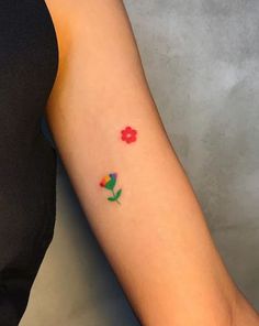 a woman's arm with flowers on it and a red flower in the middle