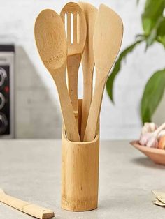 wooden utensils in a bamboo holder on a kitchen counter