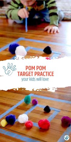 a young boy playing with pom pom target practice on the floor in front of him