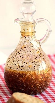 a glass bottle filled with brown liquid sitting on top of a red and white checkered table cloth