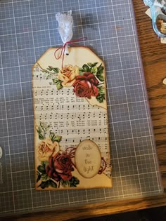 a piece of paper with flowers and music notes on it sitting on a cutting board