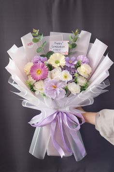 a person holding a bouquet of flowers in their hand