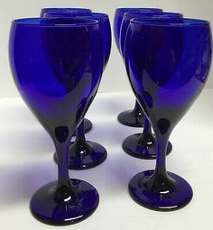 four blue glass goblets sitting side by side