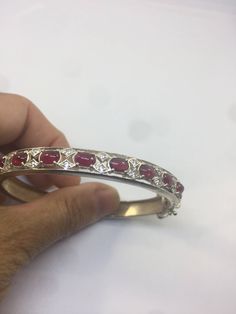 This genuine White sapphire frames bright red Rubies bracelet is very lively and bright. The stones are deep colors and well matched. The sterling silver is plated with rhodium to protect the bracelet from tarnish All jewelry is shipped in a nice gift box. Check out our over a THOUSAND great reviews Engraving is $4 per letter and is not always perfect depending on the piece. It can take a few days if the jeweler is busy. This is payable to Paypal Judithsltd@gmail.com Red Diamond Fine Jewelry Bracelet, White Gold Gemstone Bangle, Fine Jewelry White Gold Gemstone Bangle, White Gold Gemstone Bangle Fine Jewelry, Red Diamond Bracelets Fine Jewelry, Red Oval Diamond Bracelet As Gift, Red Oval Diamond Bracelet For Gift, Red Oval Diamond Bracelet Gift, White Gold Ruby Multi-stone Jewelry