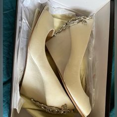 two pairs of high heeled shoes in a box with chains on the bottom and side