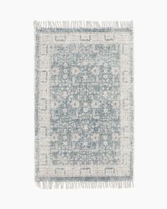 a blue and white rug with fringes on the bottom, in front of a white background