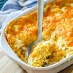 a casserole in a white dish with a serving utensil sticking out of it