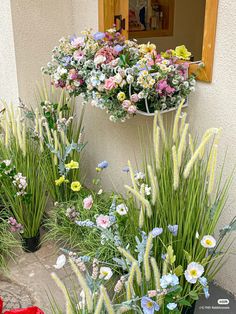 some very pretty flowers by the side of a building