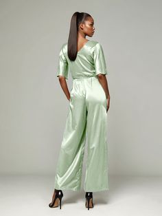 This soft satin jumpsuit features a flattering v-neck design, making it the perfect choice for mothers of the bride. Its dress pantsuit style provides comfort and elegance, while its high-quality material ensures a polished look. Stay stylish and comfortable on that special day with our jumpsuit. Chic Satin V-neck Jumpsuits And Rompers, Fitted V-neck Evening Sets, Elegant Satin Jumpsuit Or Romper In Solid Color, Formal Satin V-neck Jumpsuit, Elegant Satin Pantsuit For Evening, Elegant V-neck Spring Pantsuit, Elegant Wide Leg Sets, Elegant Satin Jumpsuits And Rompers For Workwear, Elegant Silk V-neck Jumpsuits And Rompers