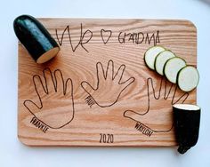 a wooden cutting board topped with cucumbers next to a knife and some writing on it