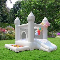 an inflatable bouncy castle with balloons on the lawn