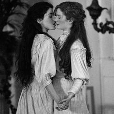 two young women are kissing each other in black and white