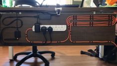 the back end of a desk with wires and cords on it