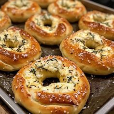 baked bagels with cheese and herbs on a baking sheet, ready to be eaten