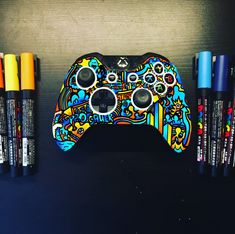 a game controller sitting on top of a table next to marker pens and pencils