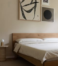 a bed sitting in a bedroom next to two pictures on the wall