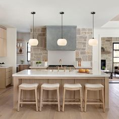 a kitchen island with three stools in front of it and an open floor plan