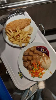 two plates with different types of food sitting on top of a white tray next to each other