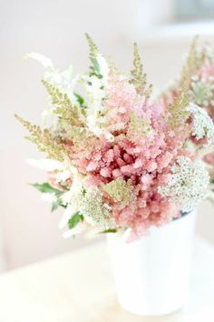 pink and white flowers in a vase on a table