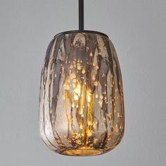 a glass light hanging from a ceiling fixture with water droplets on the bottom and inside