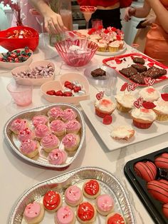 a table filled with valentine's day desserts and cupcakes