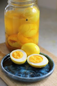 two halves of hard boiled eggs on a plate next to a jar of lemons