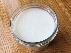 a glass filled with milk sitting on top of a wooden table