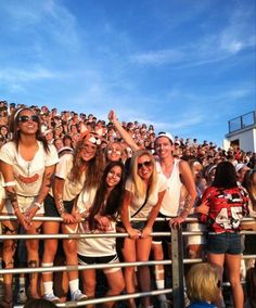 a group of young women standing next to each other in front of a crowd