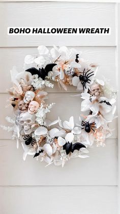 a wreath with white flowers and black bats on the side of a door, decorated with stars