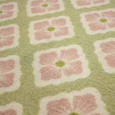 a green and pink rug with flowers on it