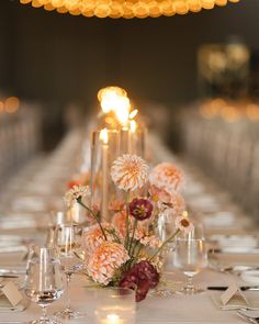 the table is set with flowers and candles for an elegant wedding reception or special event