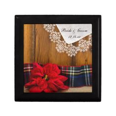 a red poinsettia sitting on top of a plaid blanket next to a wooden wall