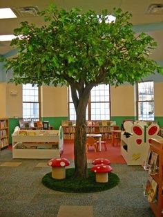 a tree in the middle of a library filled with children's books