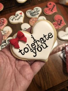 someone is holding up a decorated cookie in the shape of a heart that says i love you