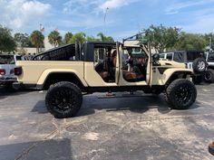 a tan jeep is parked in a parking lot