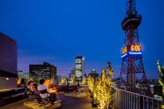 people are sitting on the roof of a building at night with lights in front of them