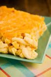 a green plate topped with food on top of a checkered tablecloth covered table