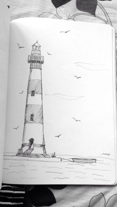 an open book with a drawing of a lighthouse on it