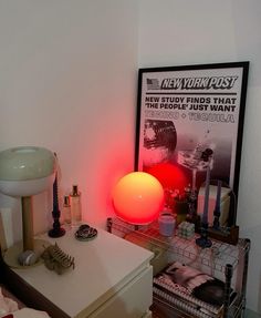 a bedroom with a bed, nightstand and poster on the wall next to an illuminated lamp