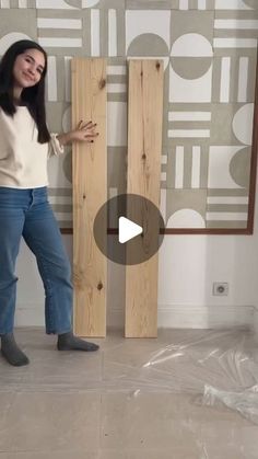 a woman standing next to two wooden boards