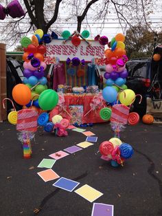 an outdoor candy cart decorated with balloons and streamers