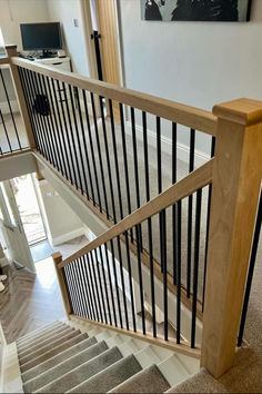 a staircase with black railing and wood handrails