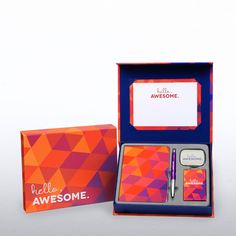 an orange and pink gift box with a notepad, pen and magnet in it