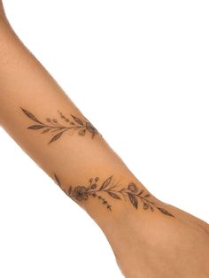 a woman's arm with a tattoo on it and flowers in the middle of her arm